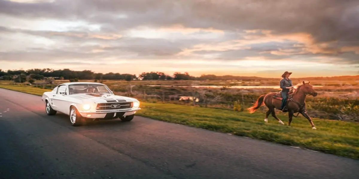 Classic Ford Mustang driving on country road