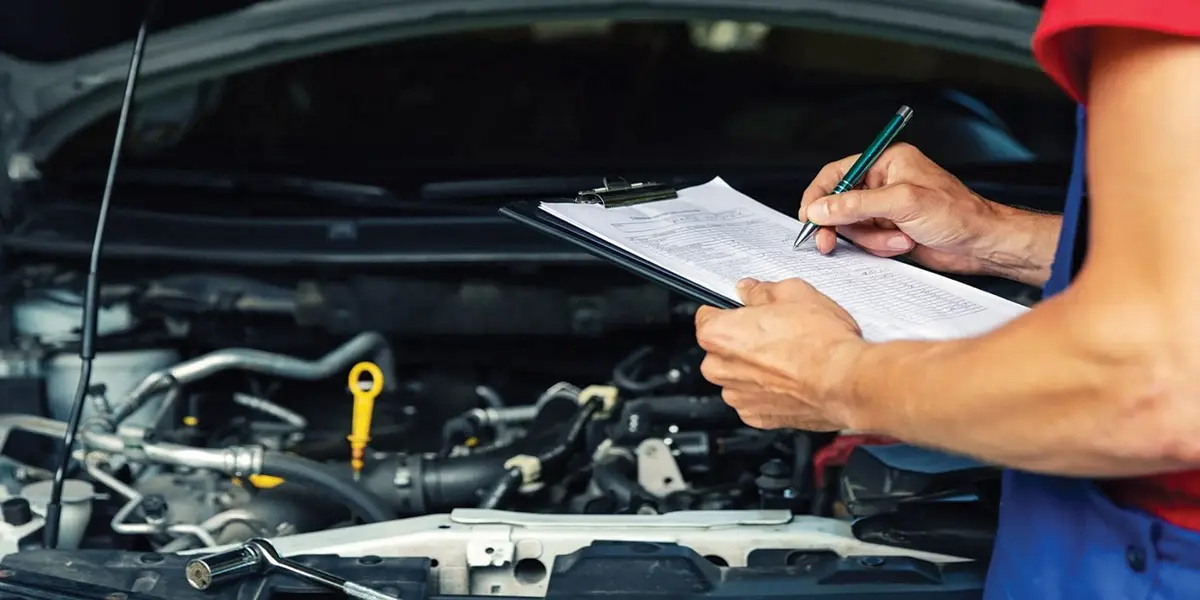 Mechanic performing a pre-purchase inspection on used car suspension and brakes