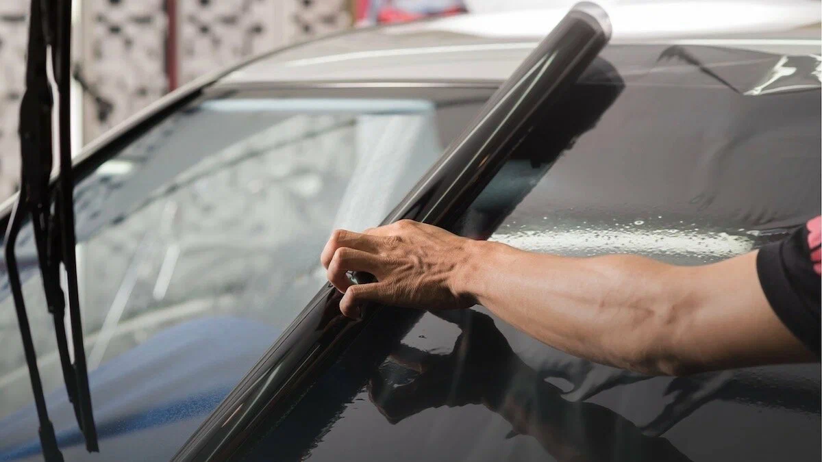 Three samples of car window tinting film comparing dyed, carbon, and ceramic materials for heat rejection