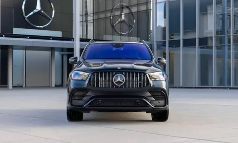 Black Mercedes-Benz SUV parked outside a Mercedes-Benz dealership, shown from the front with the brand logo visible on the building.