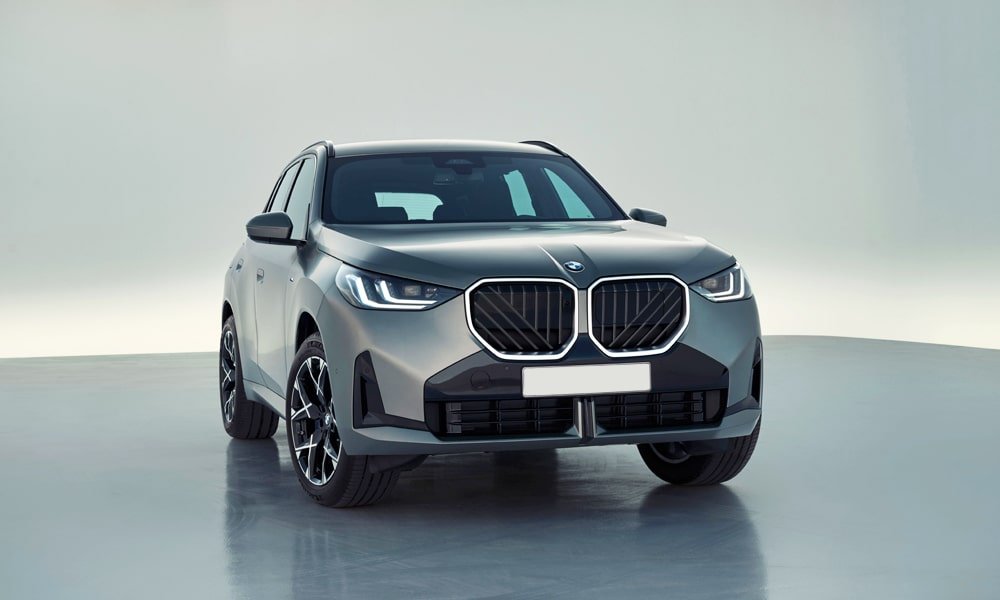 Front view of a matte grey BMW X3 showing its illuminated kidney grille and LED headlights.