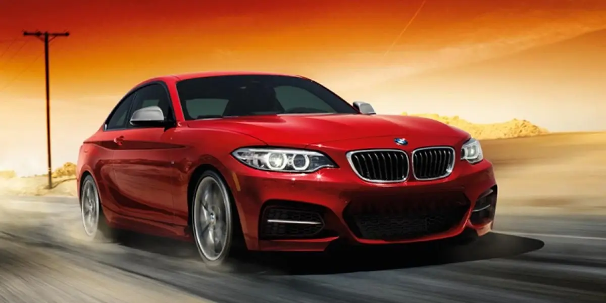 BMW 2 Series Coupe driving on a winding road, realistic professional car photography.