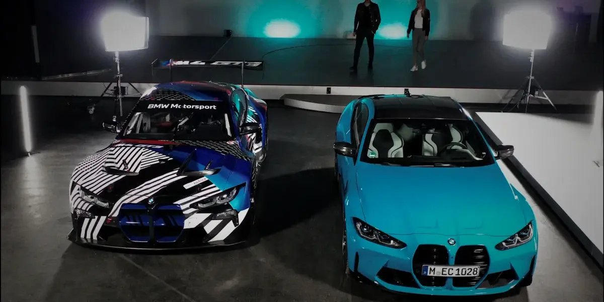 A light blue BMW M4 coupe parked next to a BMW M4 GT3 race car in a studio setup