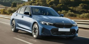 Front-three-quarter view of the 2027 BMW 330 Sedan driving on an open road.